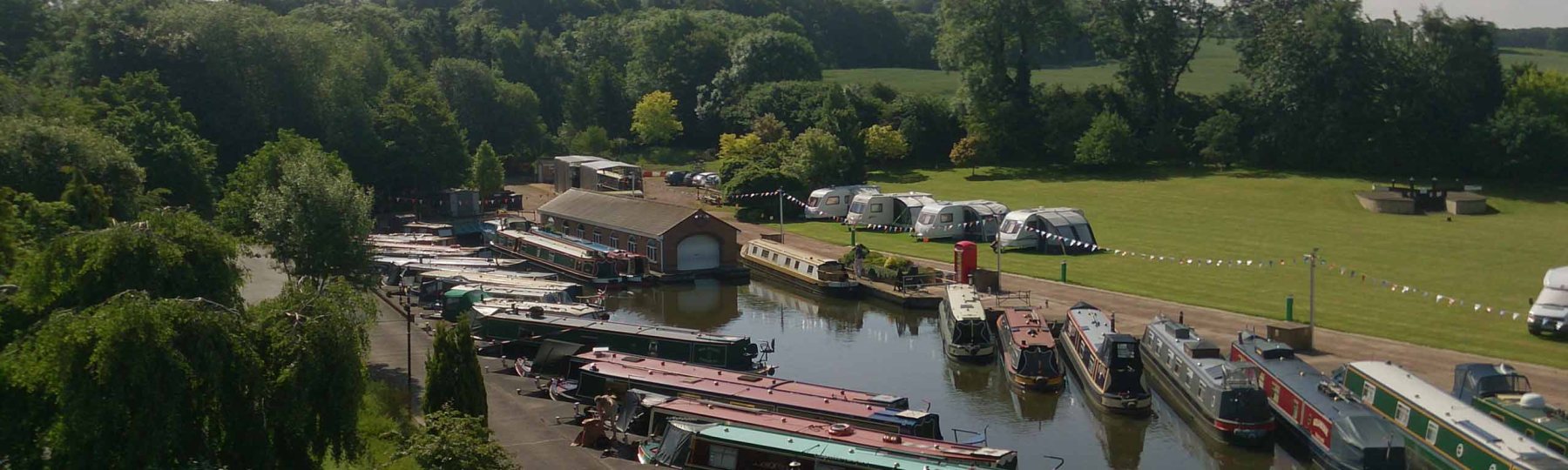 Narrowboats moored along the Hazlestrine Arm at Stafford Boat Club, seen from the air
