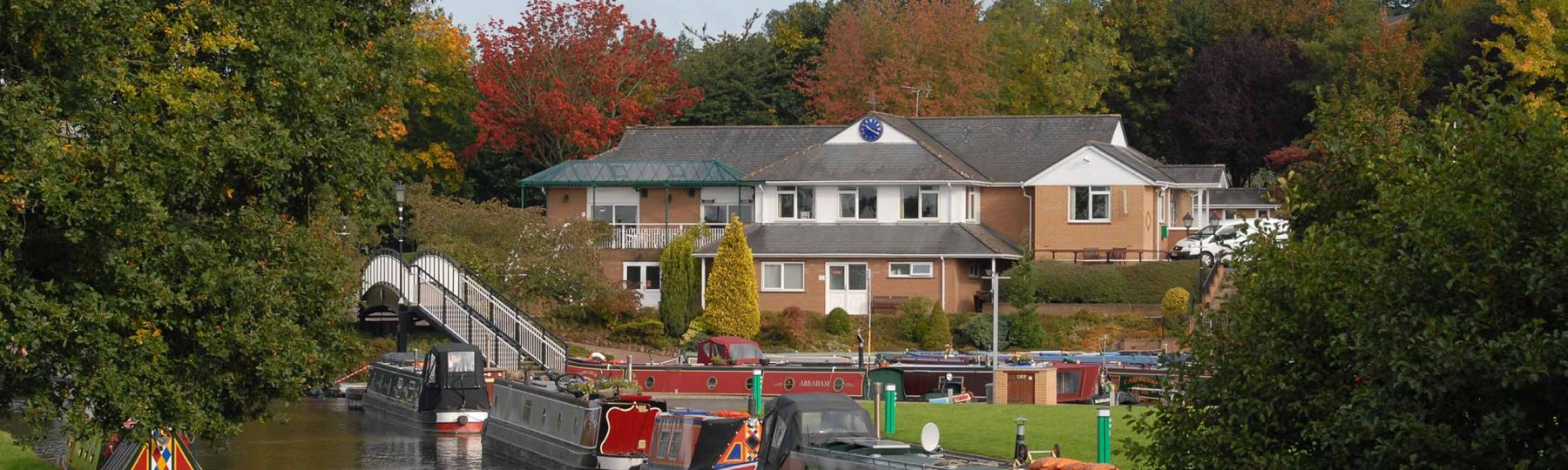 Narrowboats moored beside the clubhouse on an autumn afternoon